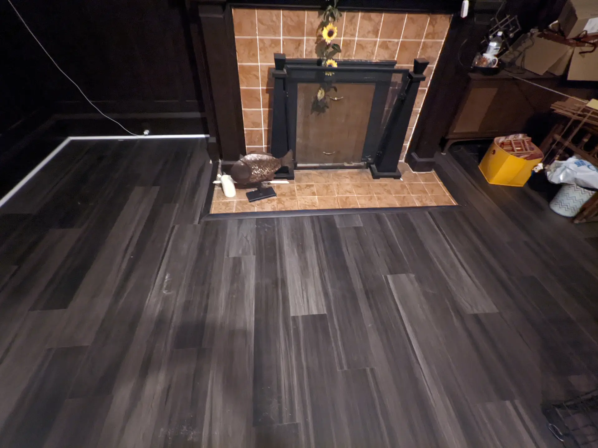 Charcoal vinyl plank flooring in a den with a brick fireplace