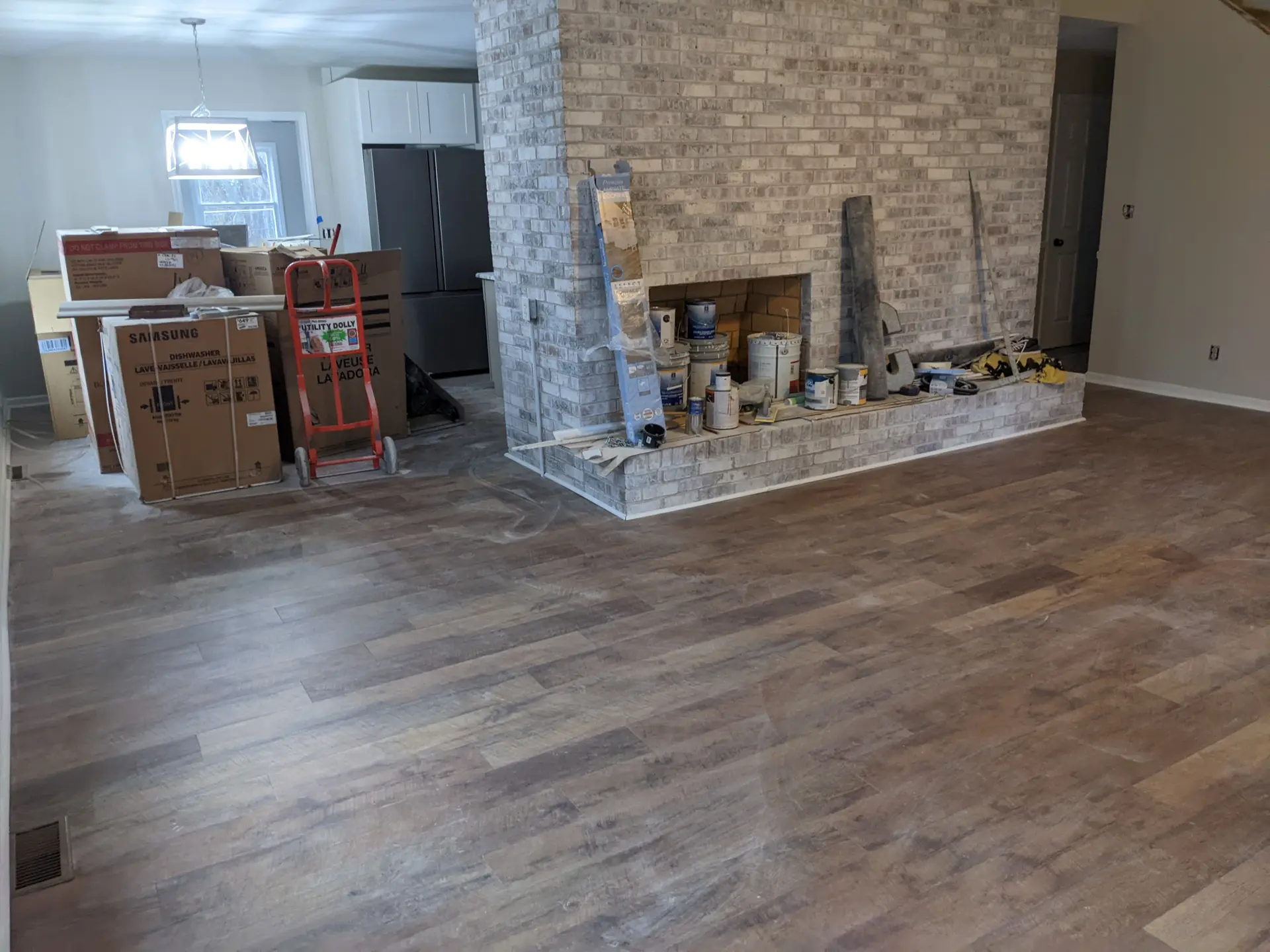 Open living room with new hand-scraped plank flooring and stone fireplace