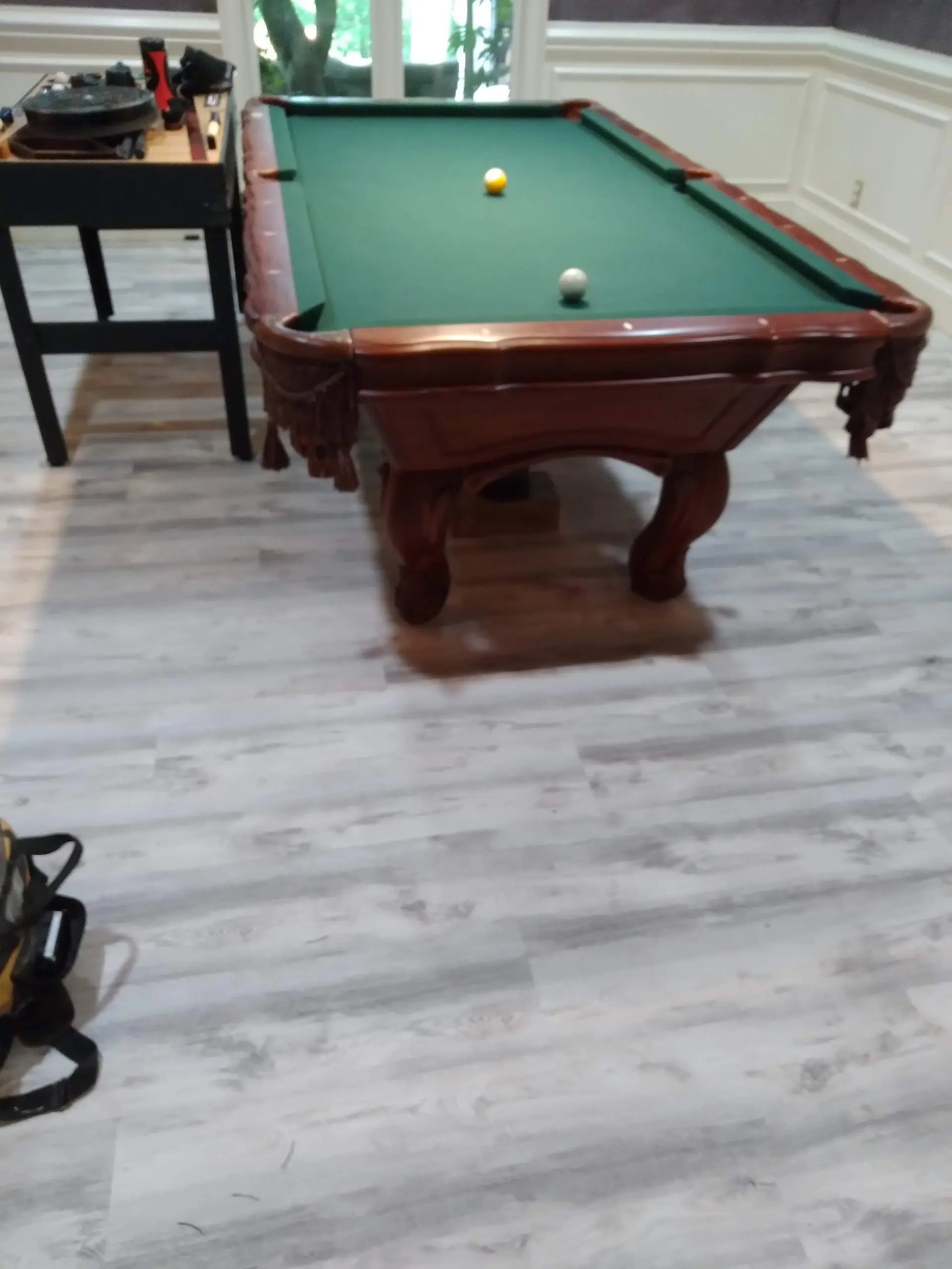 Whitewashed vinyl plank flooring in a game room with a pool table